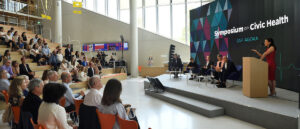 People speaking on a stage.