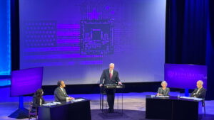 People on a panel on a stage.