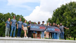Student holding a Hopkins Votes banner.